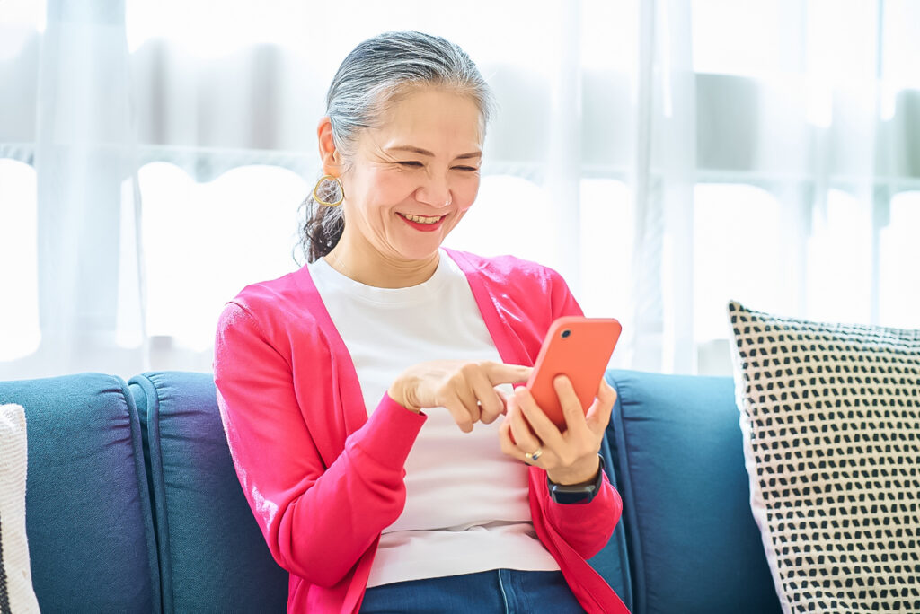 スマホをタップする高齢女性