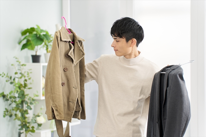 ２つの服を持つ男性