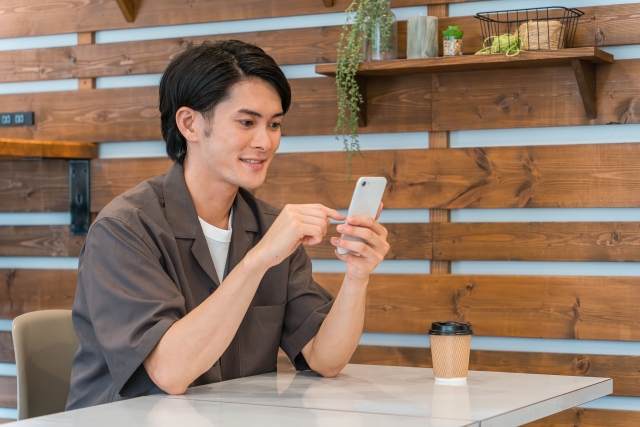 笑顔でスマホを見る男性