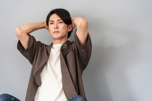 座って悩み顔の若い男性