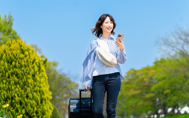 スーツケースを引く若い女性