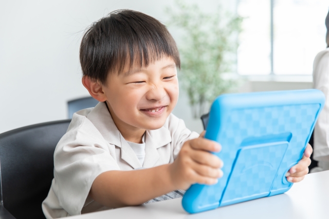 iPadに笑顔の子ども
