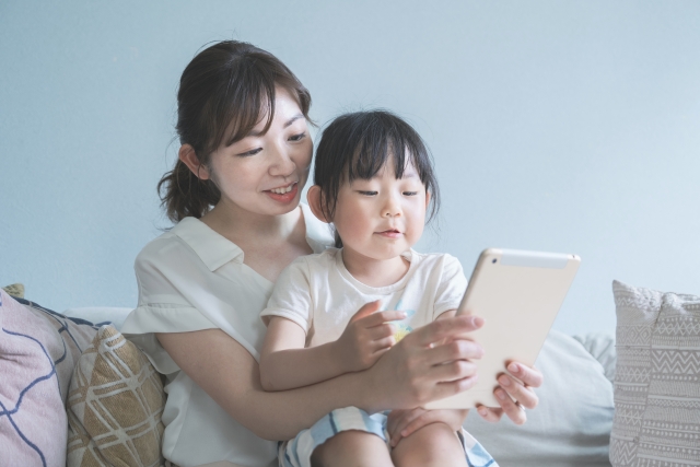 タブレットを見る母と娘